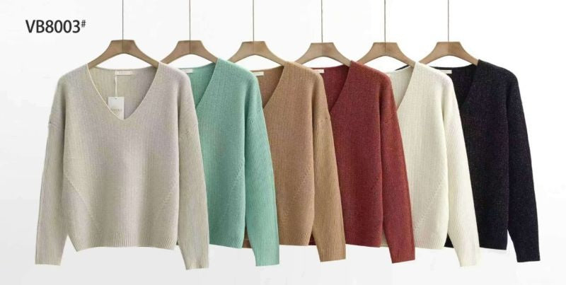 Alignement de six pulls en maille à col V dans différentes couleurs : beige, vert menthe, camel, rouge brique, écru et noir, suspendus sur cintres sur fond blanc.